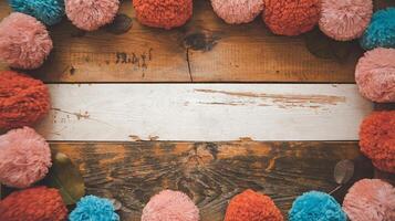 Rustic Wooden Table Background with Bright Red Blue and Pink Yarn Pom Poms in Circular Border photo