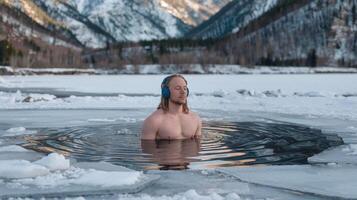 Man Practicing Ice Bath Therapy Immersed in Frozen Lake with Snowy Mountains in Winter photo
