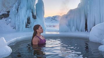 Woman Relaxing in Outdoor Hot Spring Surrounded by Ice Formations and Snowy Mountains at Sunset photo