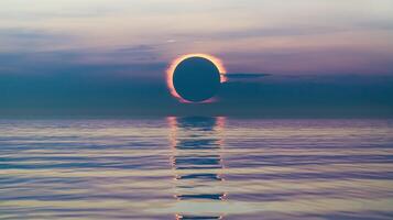 Solar Eclipse Over Calm Ocean Reflecting Vibrant Twilight Colors in Serene Sky at Sunrise or Sunset photo