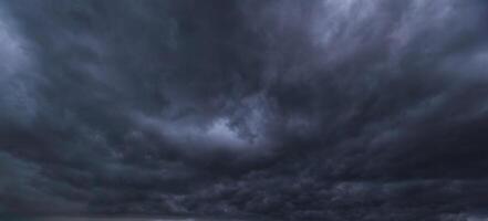 Bad or moody weather sky and environment. carbon dioxide emissions, greenhouse effect, global warming, climate change. The dark sky with heavy clouds converging and a violent storm before the rain. photo