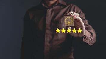 Hand of a businessman show a smile face on wood block.Customer service experience and business satisfaction survey.rating very impressed.Satisfaction survey concept. photo