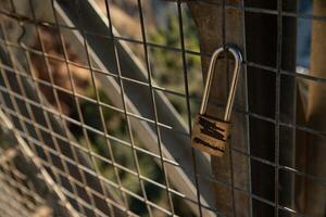 Padlock closed to a fence with names crossed out. photo