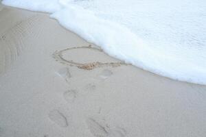Heart drawn on the beach sand photo