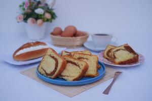 sponge cake on a blue plate with eggs and cup of tea photo