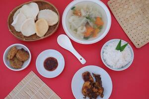 traditional Indonesian food arranged neatly on a red table photo