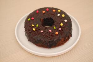 Chocolate cake on plate with wooden background photo
