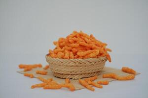 Crispy Corn Puffs in rattan on bamboo mat. Selective focus. photo