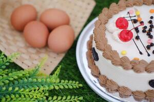 Cake with cherry on top and with a grass background. photo