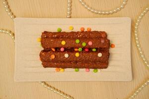 chocolate wafers on a square plate with chocolate candy on top photo