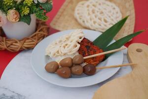 rice with grilled chicken and quail egg satay, crackers photo