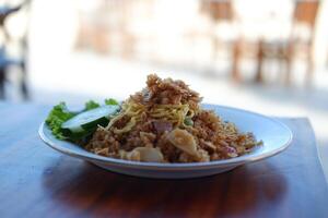 Fried rice with seafood and egg, presented on a wooden table. photo