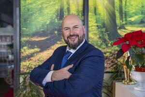 portrait of elegant businessman with beard looking at camera smiling during break in office photo