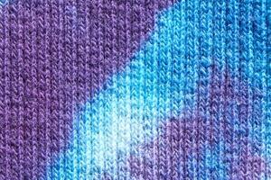 Close up of blue and purple tie dye knitted fabric texture pattern background. photo