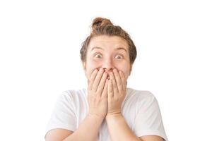 Surprised caucasian young female with hands on face and wide eyes expressing shock and excitement isolated on white background. photo