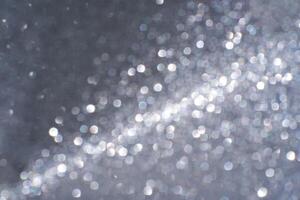 Abstract silver bokeh light pattern with circular glittering effect on dark background. photo