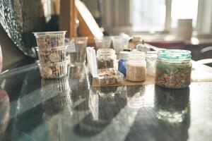 Sunlit crafting space with various jars and containers on a wooden table near a window. photo