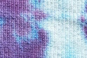 Close up of multicolored knitted fabric texture with purple and blue patterns. photo
