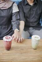 couple holding hands on a coffee date photo