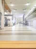 Empty wooden table, blurred background of airport corridor building. photo