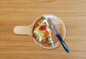 Spinach and cheese pizza, cut in half, Italian food, on a wooden table. photo