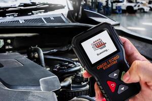OBDII Scanner in use by auto mechanic for reading fault code of the car engine system , Car repair concept photo