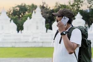 Caucasian gray-haired man tourist having remote conversation communicate speaking by smartphone with friend. photo