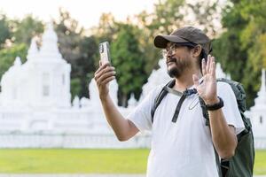 Happy tourist using mobile phone while making call during is trip. Happy man blogger photo