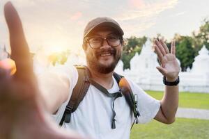 A man, a blogger, making a call using a smartphone camera. A happy man, a tourist with a mobile phone in his hands. photo