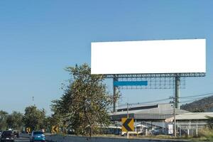 A large, blank billboard on the side of a highway. The billboard is white. It is located in a rural area, clipping path. photo