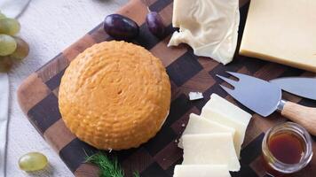 Cheese plate on gray table. Cheese platter on wooden board. Top view, slow motion video