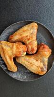 Grilled chicken wings with spices on dark concrete background video