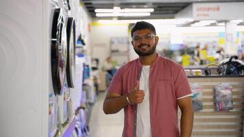 Indian man buying a smart washing machine in tech store video