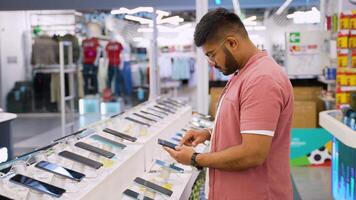 Indian man buying a new smartphone with discount in a tech store video