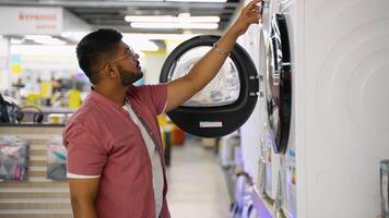 Indian man chooses a smart washing machine in tech store video