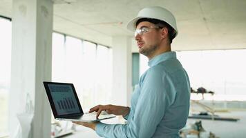 Engineer using laptop for progress tracking on-site video