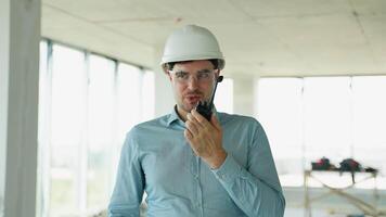 Engineer managing construction with radio and laptop video