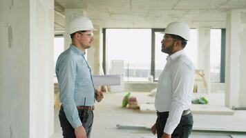 Engineer checking digital plans on construction site video