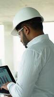 Indian Builder Engineer Reviewing Data on Laptop at Construction Site video