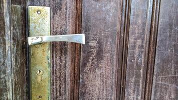 Old door handle on a wooden door photo