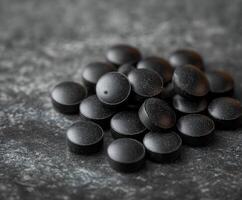 Health supplements stacked on a dark surface with soft shadows and textures photo