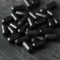 Various black capsules scattered on a textured surface photo