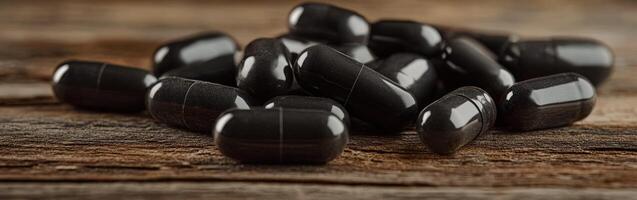 Black capsules scattered on a wooden surface during daylight hours photo