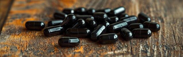 Black capsules scattered on a rustic wooden surface in a warm setting photo