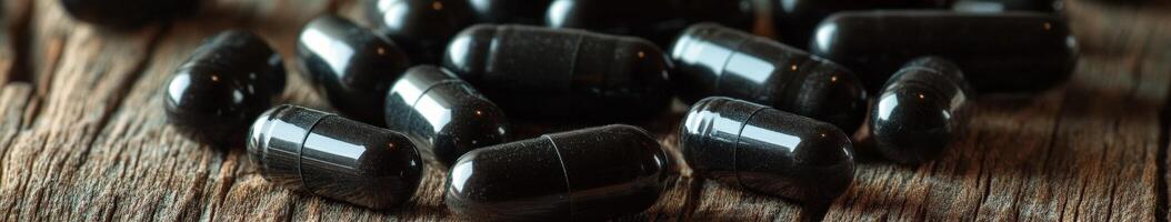 Natural health supplements on wooden surface showcasing black capsules photo