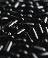 Dark glossy capsules scattered on a surface in an abstract display photo