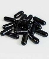 Collection of black capsules arranged on a white background for display photo