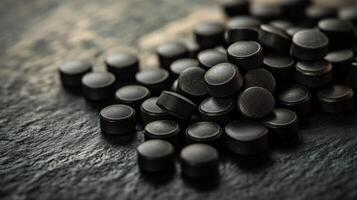 Black dietary supplements scattered on a textured surface for health emphasis photo