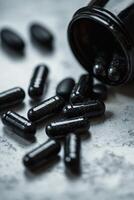 Black capsules spilled from a bottle on a textured surface in a natural light photo