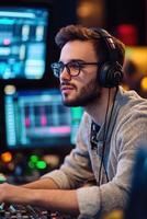 Young man focused on music production in a modern studio setting photo